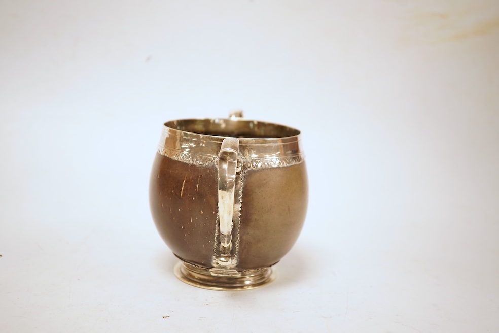A late 19th/early 20th century white metal mounted two handled coconut cup, with engraved mounts and initials 'A IL', height 10cm (unmarked).